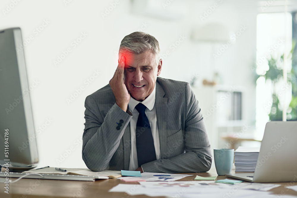 Running a business can be a real pain. Shot of a businessman with a headache holding his head while 