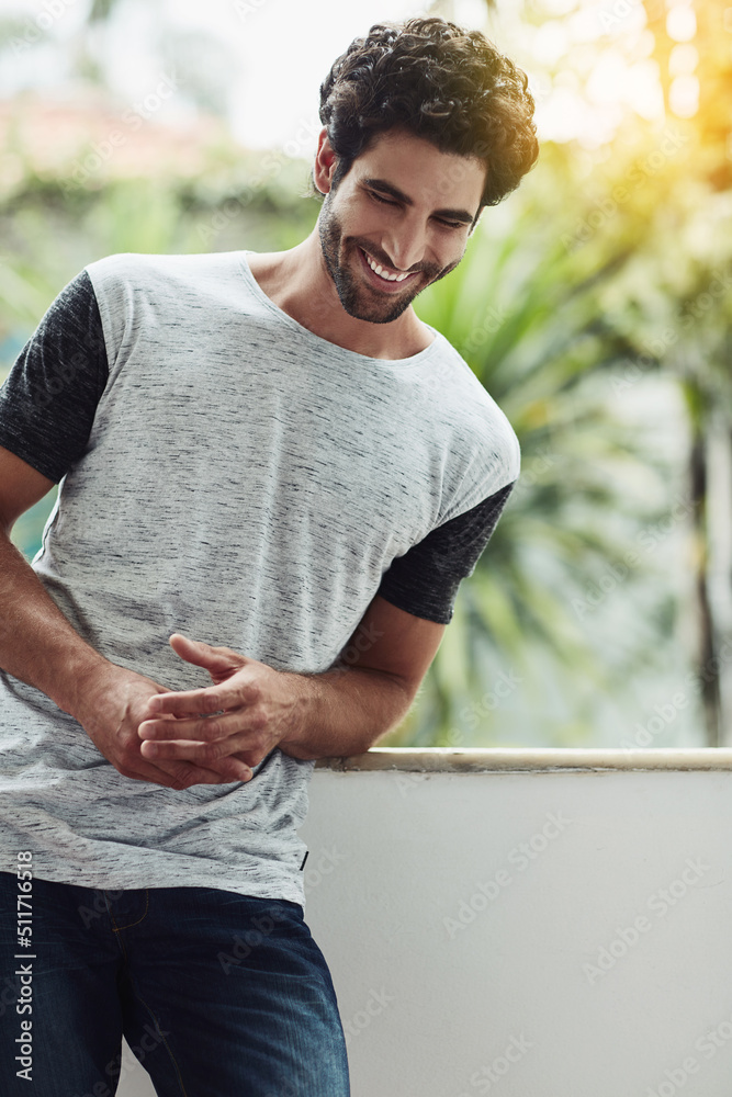 Thinking about the splendid day I had makes me laugh. Cropped shot of a handsome young man at home.