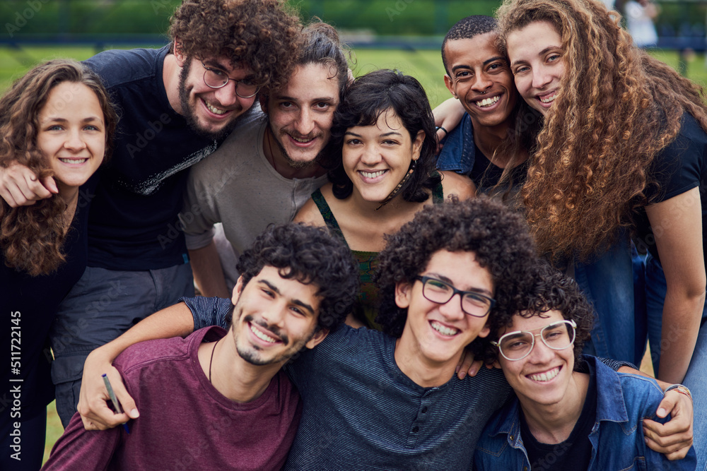 Life is brighter with friends. Portrait of a group of young students standing arms around each other