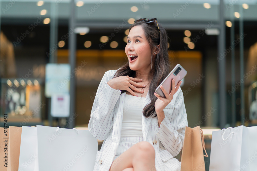 退出快乐的亚洲女性在智能手机上大惊喜布折扣短信秀，亚洲女性使用智能手机