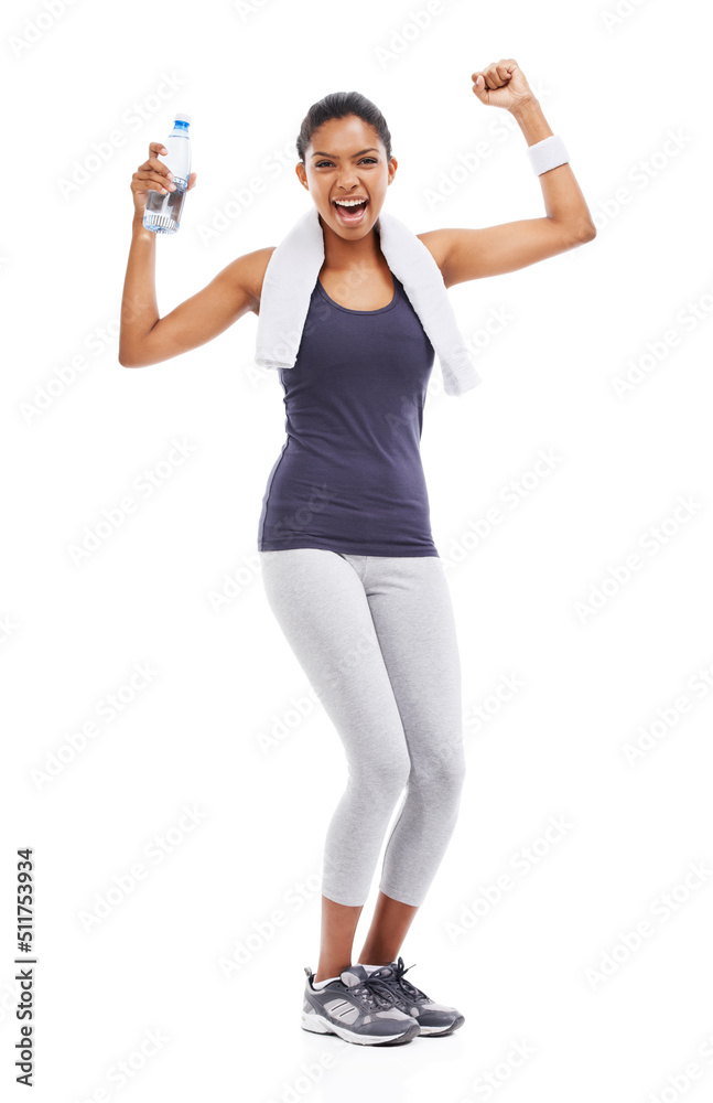 Shes reaching her fitness goals. A young woman holding a bottle of water and flexing her biceps afte