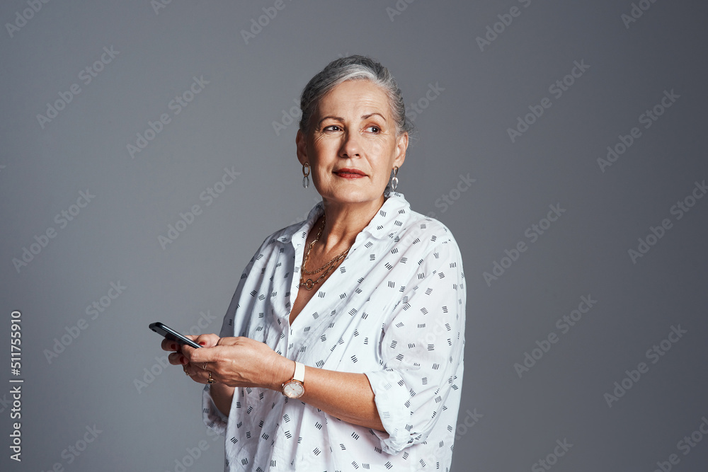 Theres an app for everything. Studio shot of a senior woman using her cellphone while standing again