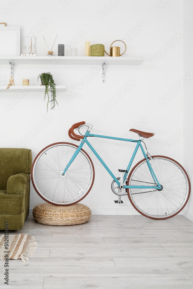 Modern bicycle and sofa near light wall in living room