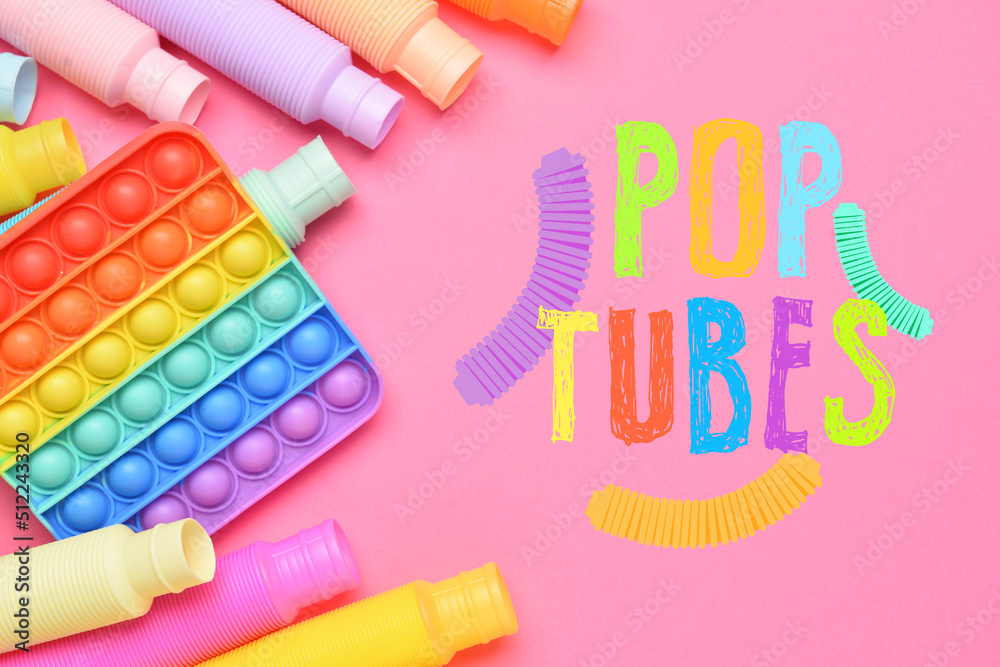 粉色背景下不同颜色的Pop Tubes和Pop-It玩具