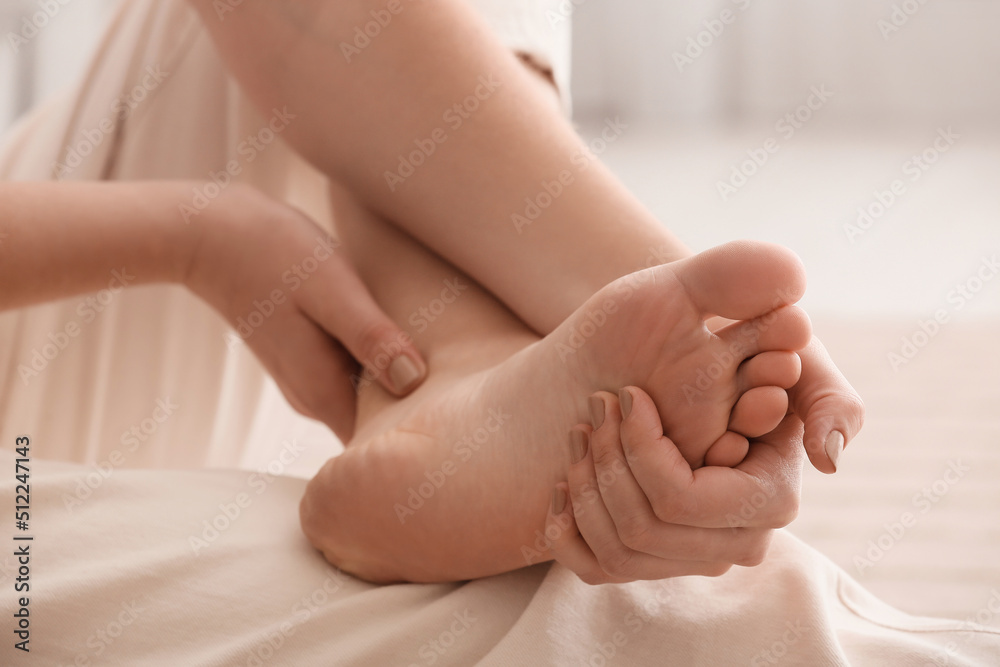 Young woman making foot massage, closeup