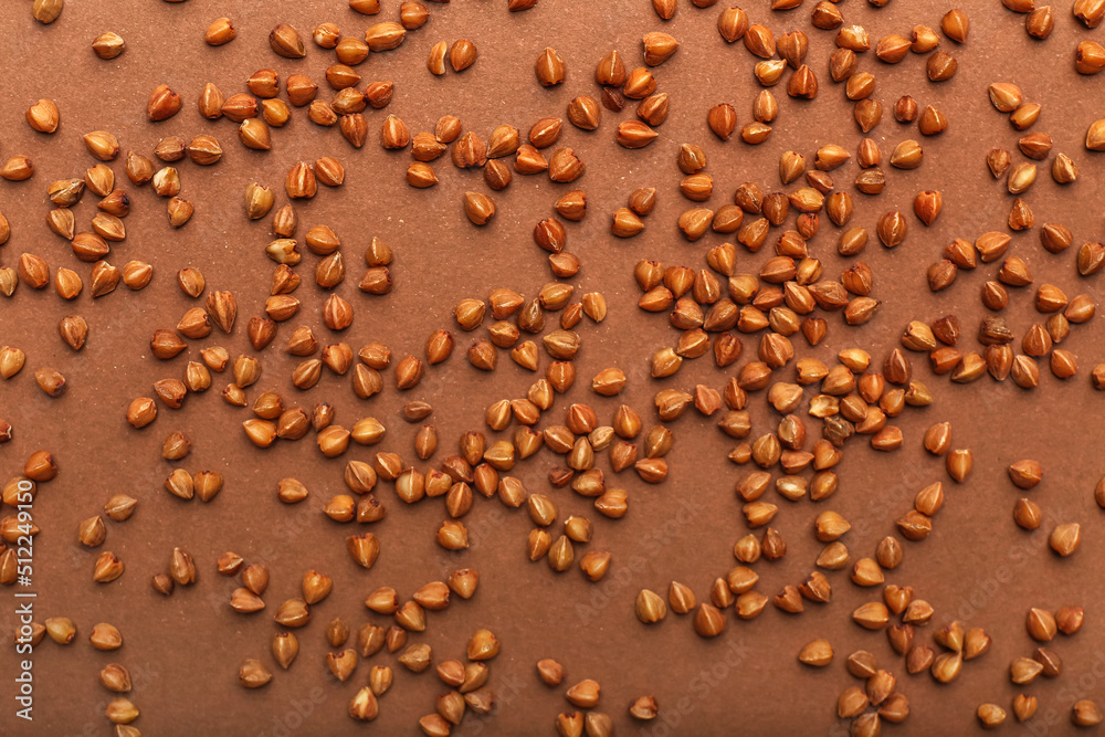 Scattered buckwheat grains on color background