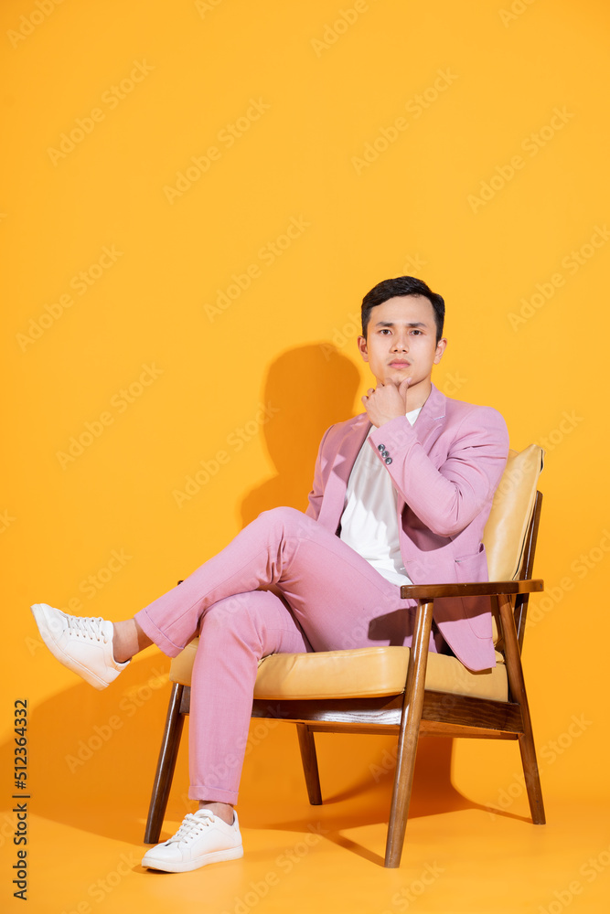 Image of young Asian man sitting on chair