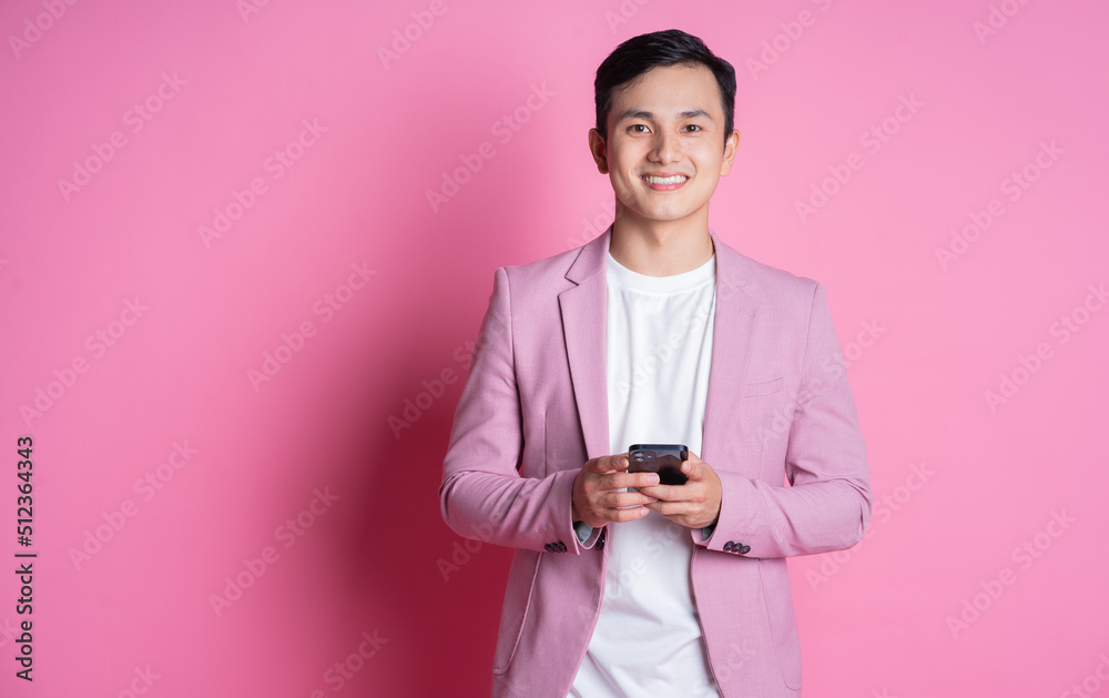 Portrait of young Asian man wearing pink suit posing on background