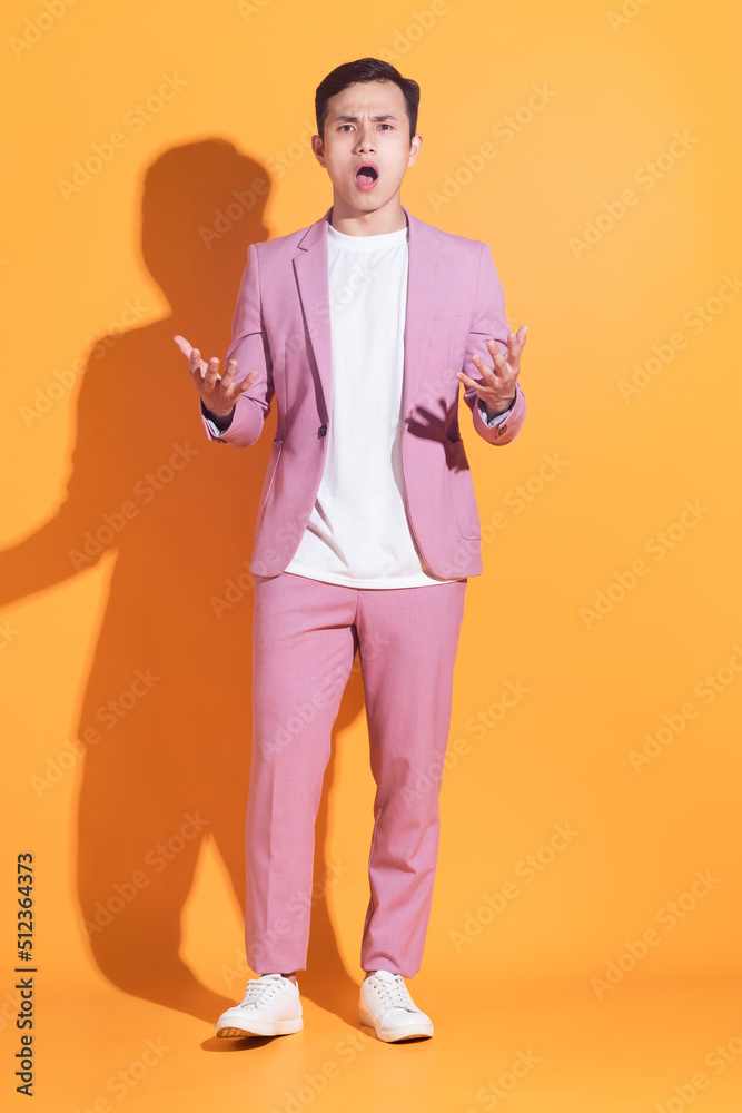 Portrait of young Asian man posing on background