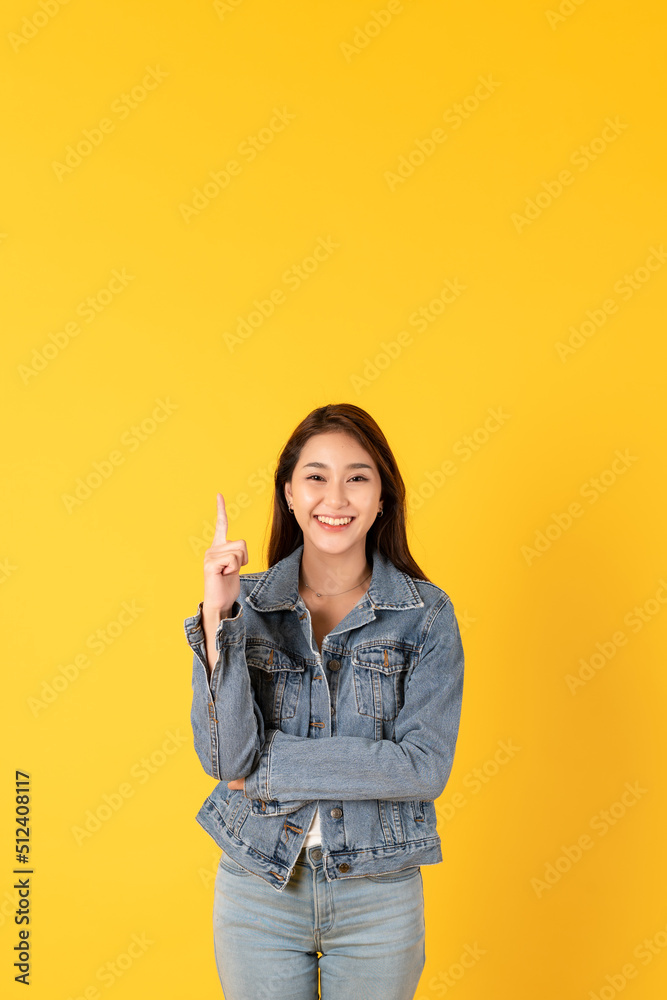 Happy good looking young woman wearing jacket outfit isolated on yellow background pointing at copy 