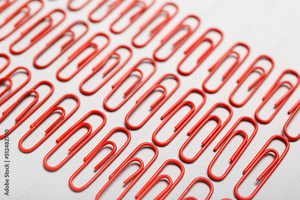 Red paper clips on light background, closeup