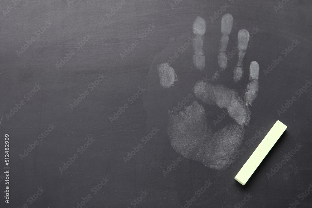 Handprint with chalk on school blackboard