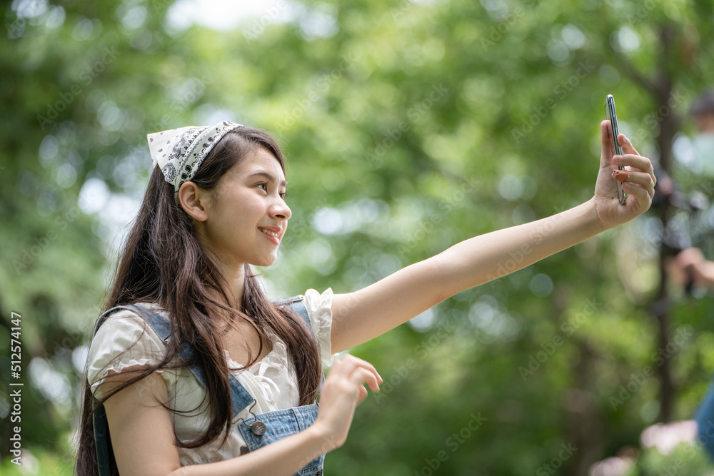 Thoughtful smile woman in park using smart phone for selfie photo , Portrait of a young charming bus