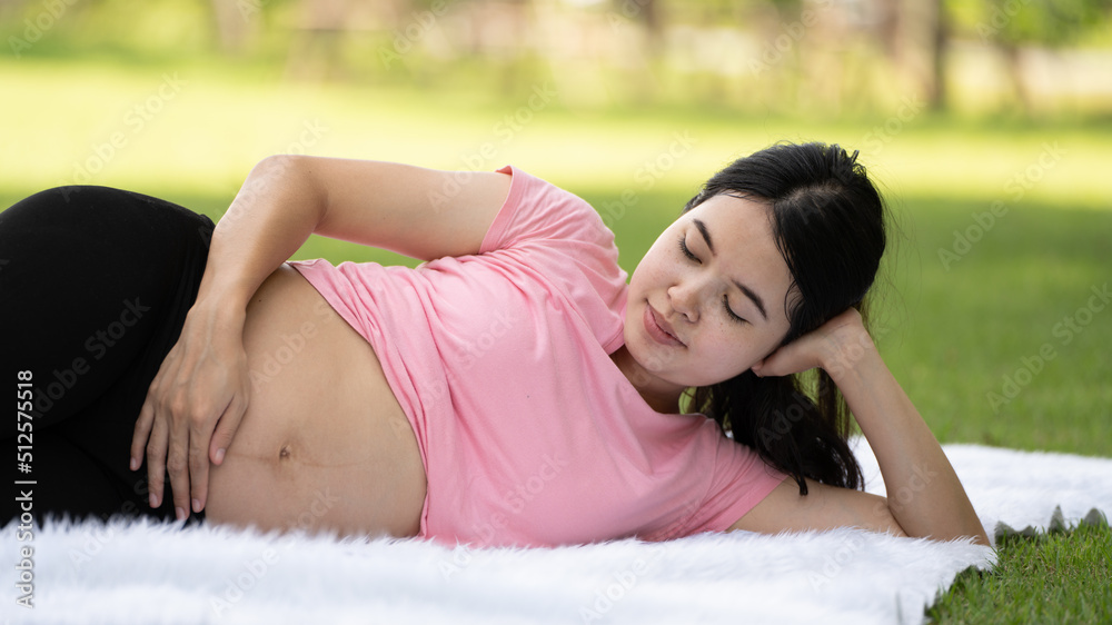 Pregnant woman touching belly in the City Park, Pregnant Relaxing and exercise, Beautiful tender moo