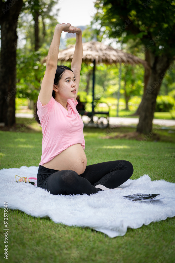 孕妇在城市公园摸肚子，孕妇放松和锻炼，美丽温柔的麋鹿