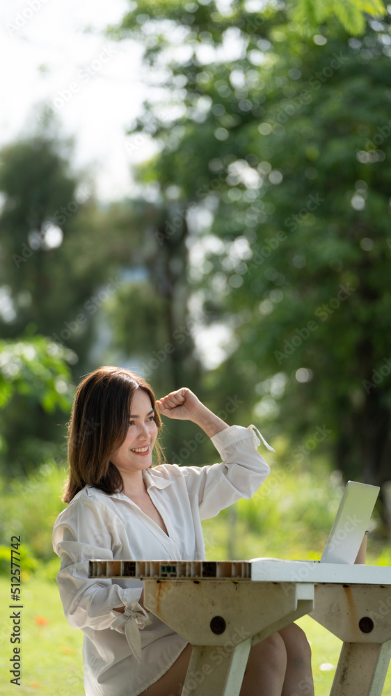 体贴的微笑快乐的女人在公园里用笔记本电脑在线视频通话或在线会议