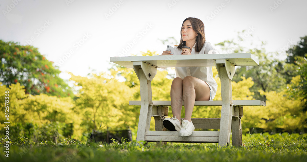 Thoughtful smile woman in park using smart phone, Portrait of a young charming business woman checki