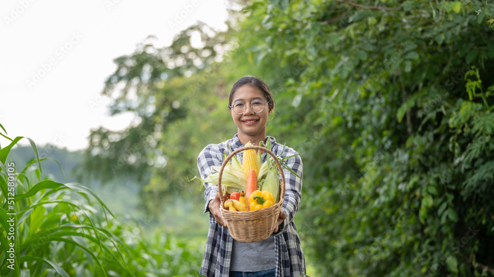 Beautiful young brunette Portrait Famer Woman hand holding Vegetables in the bamboo basket on green 