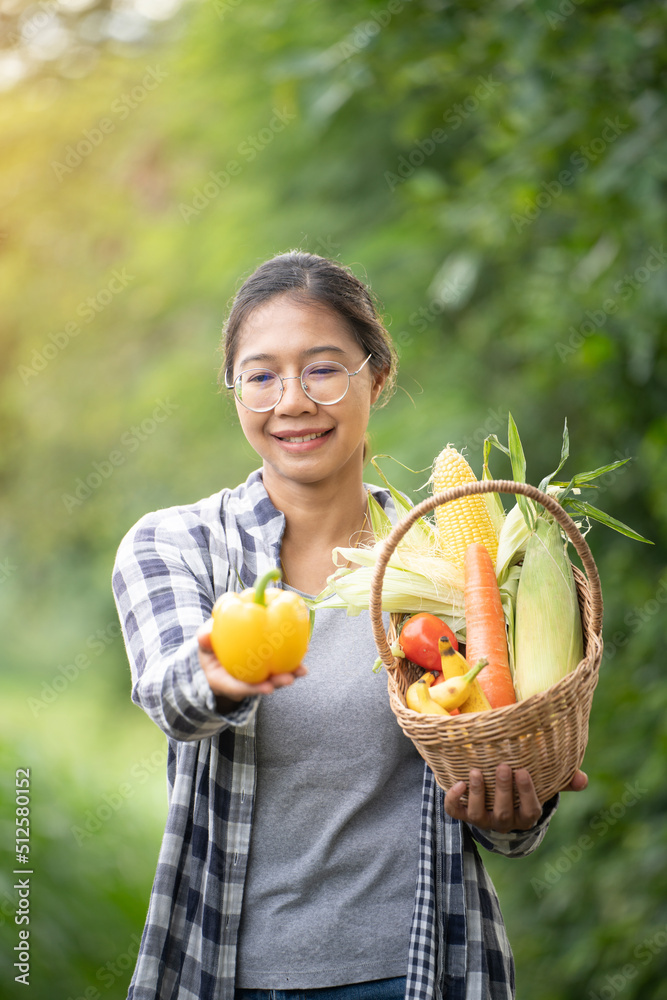 Beautiful young brunette Portrait Famer Woman hand holding Vegetables in the bamboo basket on green 