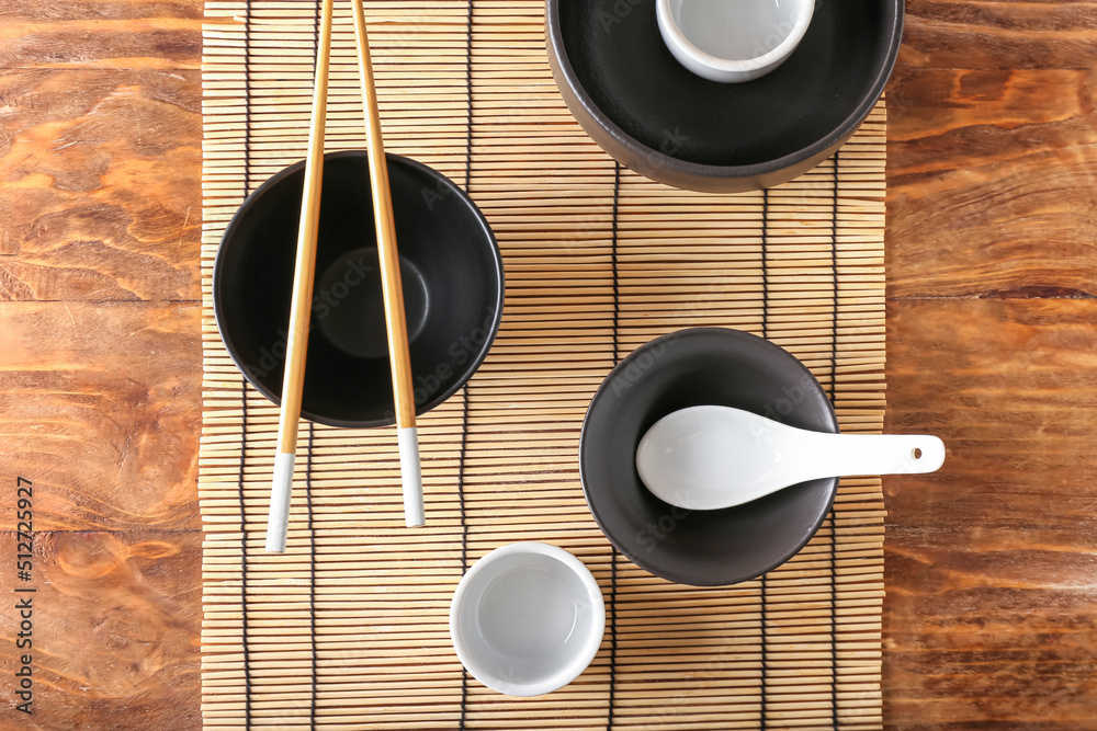 Chinese bowls with chopsticks on wooden background