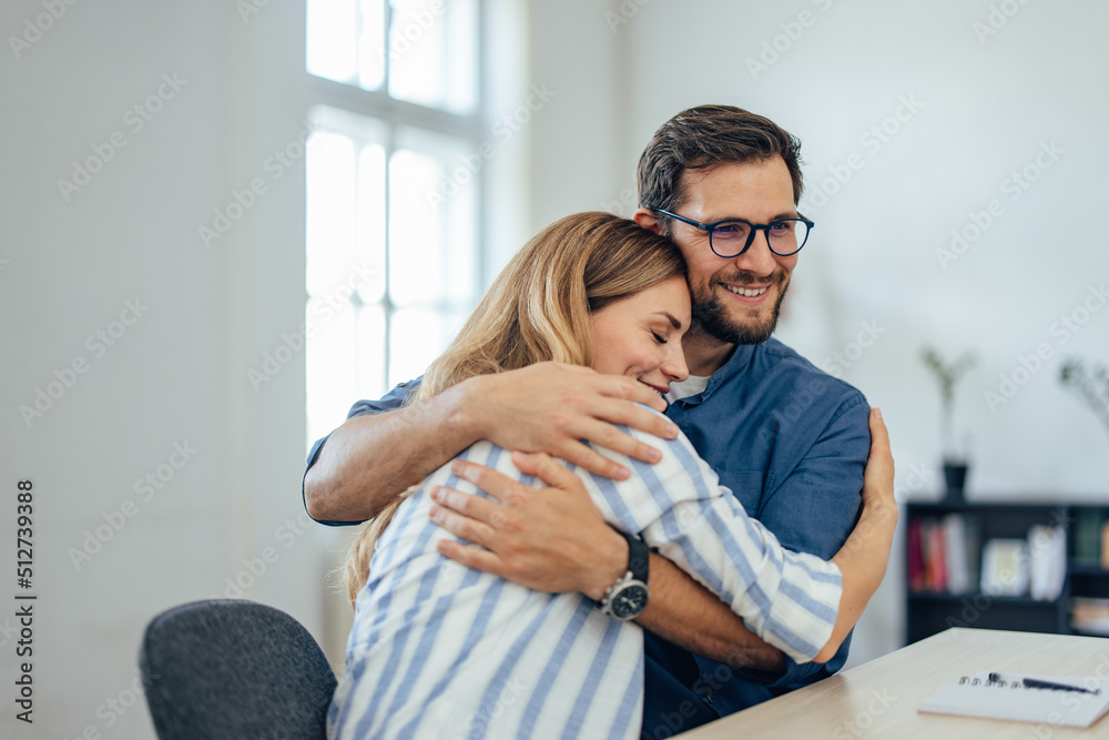 Close up of a smiling couple in a hug, just sign an insurance contract.