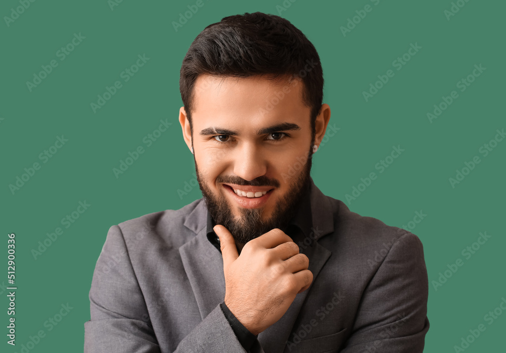 Portrait of smiling bearded man on green background