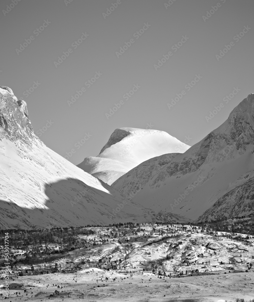 View of snow capped mountains and the glacier North of the Arctic Polar Circle in black and white. O