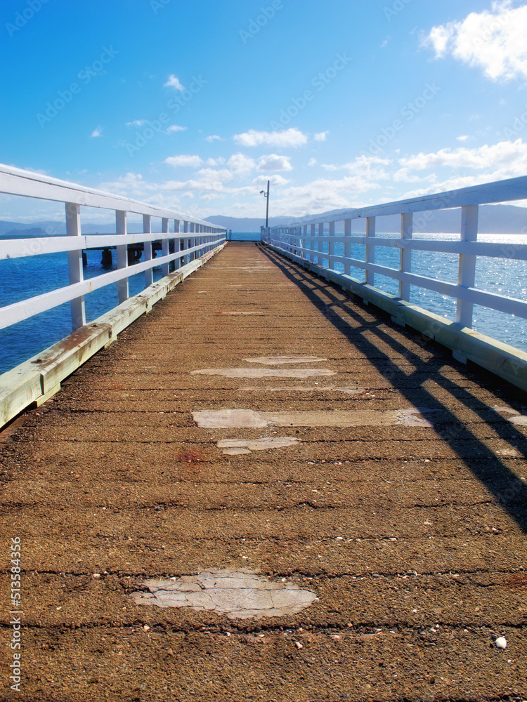 A wood pier leading into the ocean with copy space. An old empty platform or dock terrace on a lake 