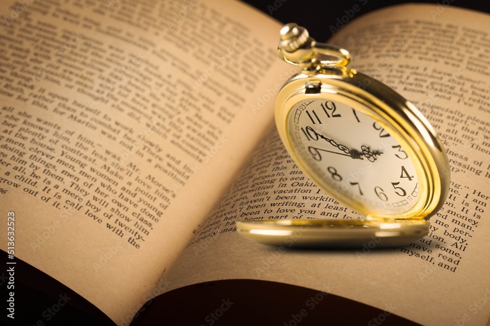 Beautiful old clock, old book on the desk