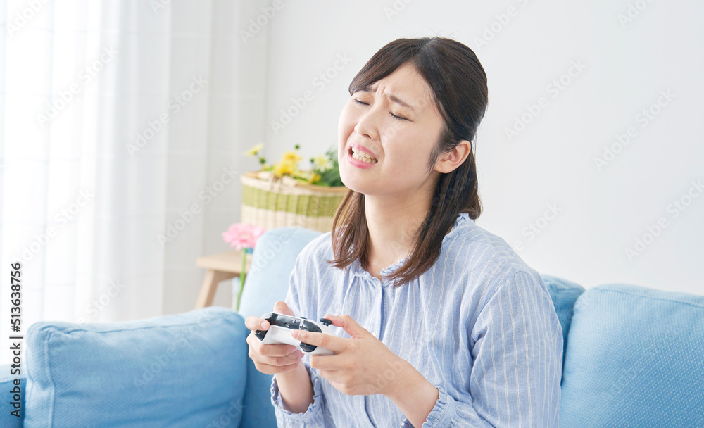 リビングで一人でテレビゲームをして落ち込む女性