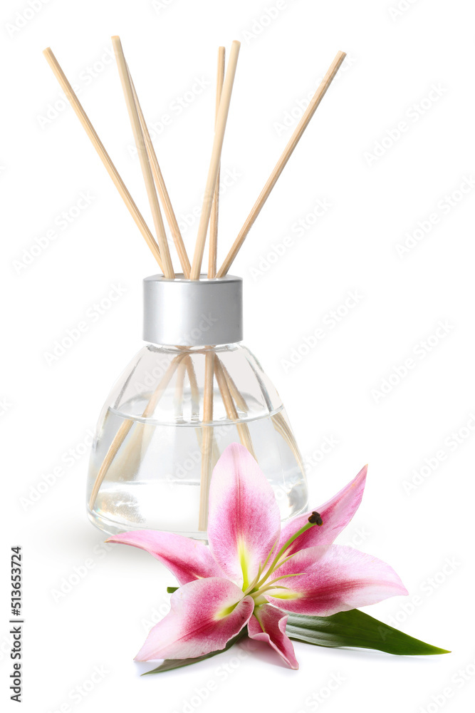 Reed diffuser and lily on white background