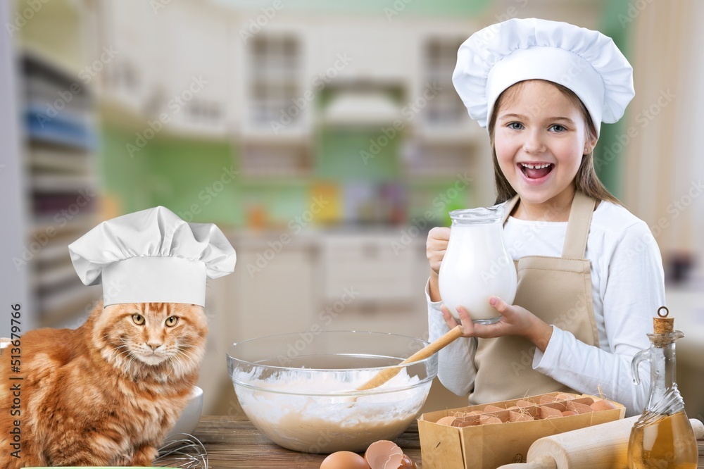 The cat chef sits at the kitchen table in a chefs hat with food.