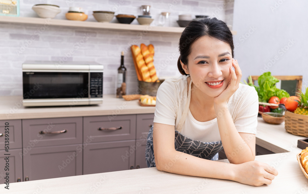 年轻的亚洲妇女正在厨房里准备做饭。