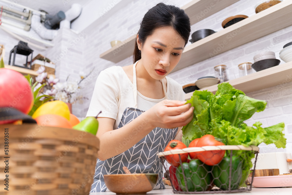 年轻的亚洲女人正在厨房里准备做饭。