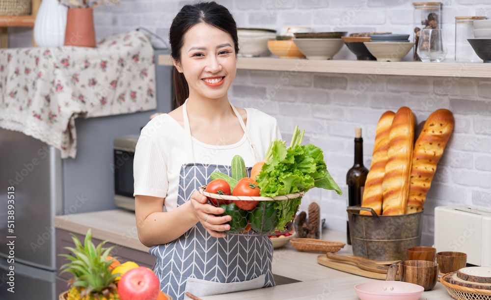 年轻的亚洲女人正在厨房里准备做饭。