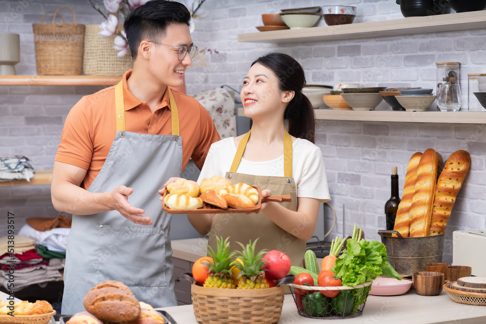 年轻的亚洲夫妇在厨房做饭的画面