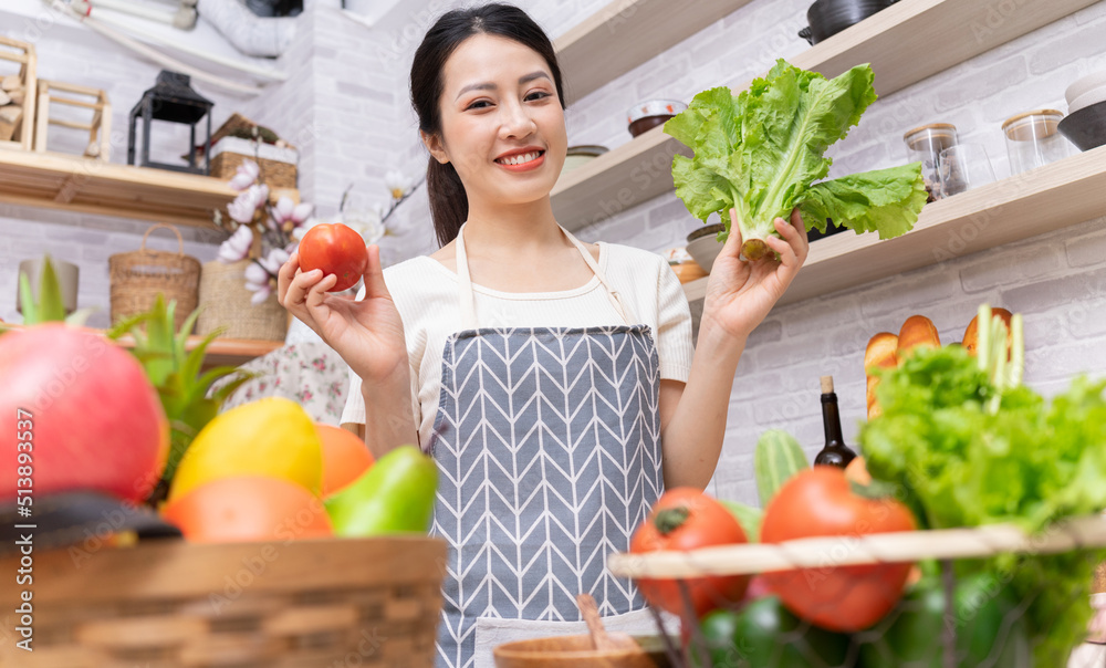 年轻的亚洲妇女正在厨房里准备做饭。