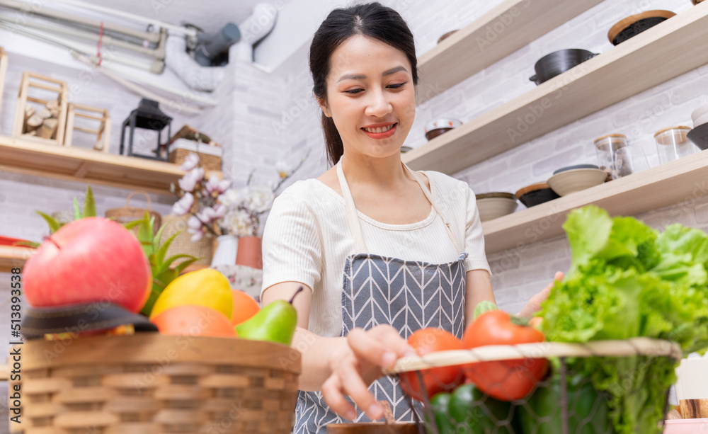 年轻的亚洲女人正在厨房里做饭。