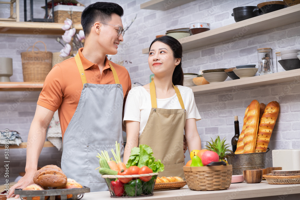 年轻的亚洲夫妇在厨房做饭的画面