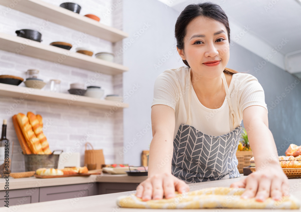 年轻的亚洲女人做饭后打扫厨房。