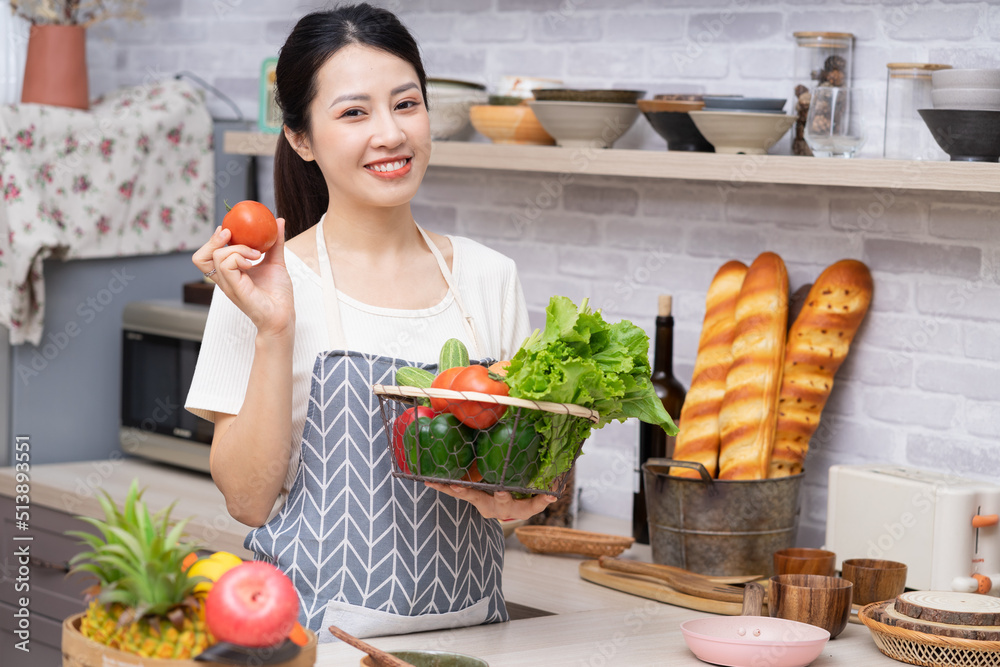 年轻的亚洲女人正在厨房里准备做饭。