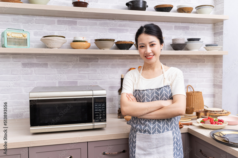 年轻的亚洲女人正在厨房里准备做饭。