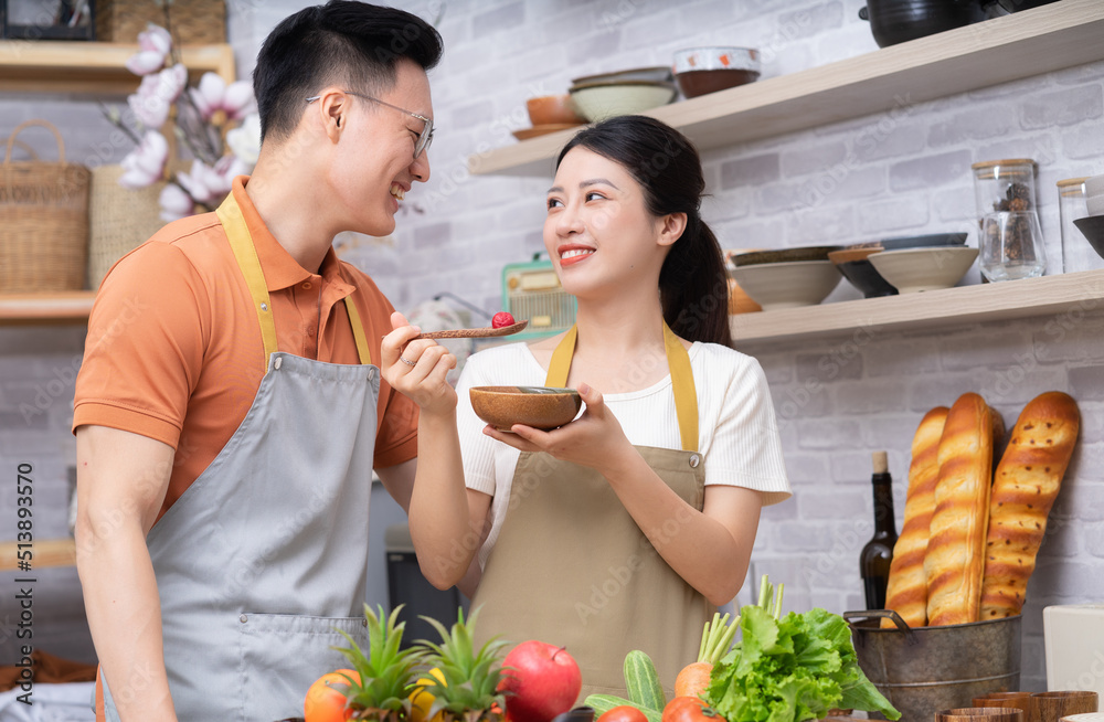 年轻的亚洲夫妇在厨房做饭的画面