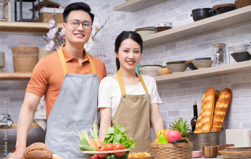 年轻的亚洲夫妇在厨房做饭的画面