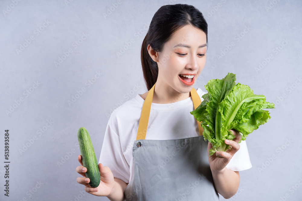 背景是拿着蔬菜的年轻亚洲女性