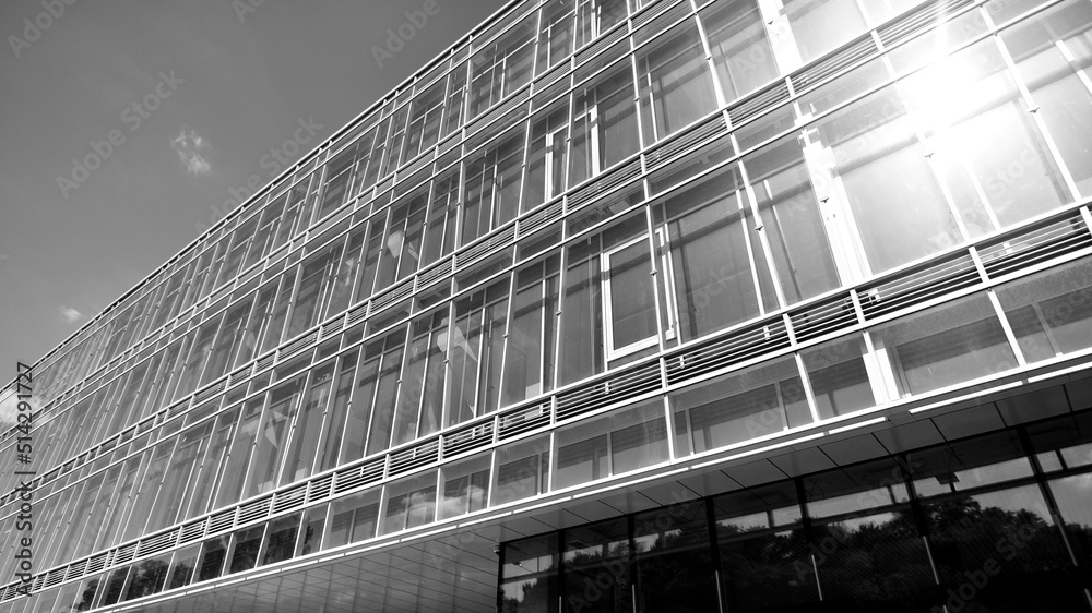 Modern office building with glass facade on a clear sky background. Transparent glass wall of office