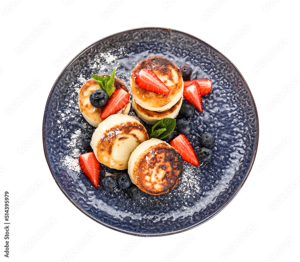 Plate with cottage cheese pancakes, fresh berries and mint leaves on white background