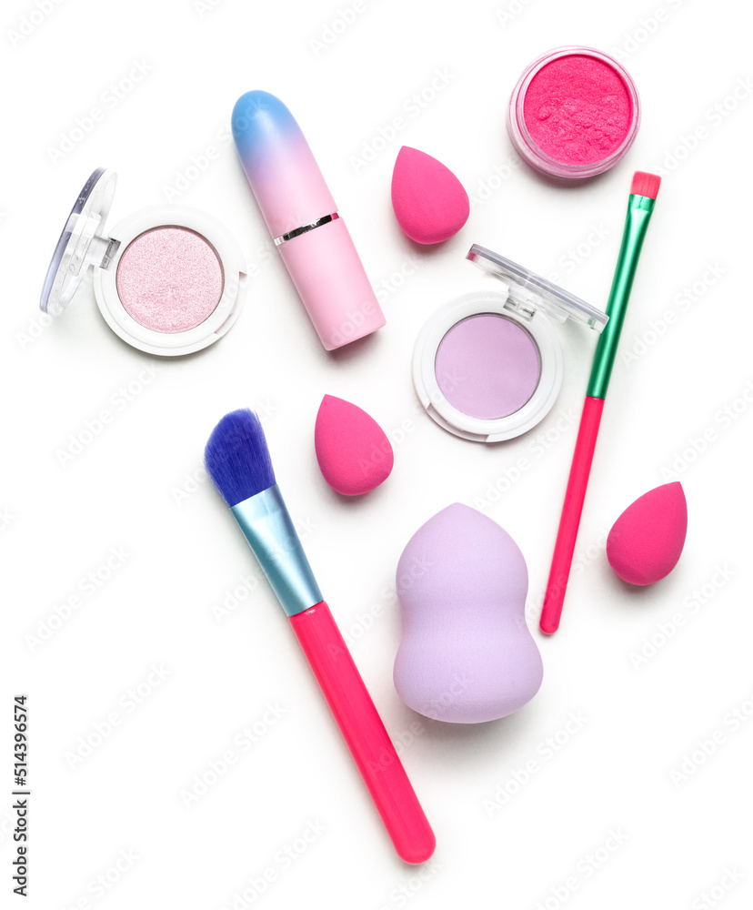 Composition with cosmetics, makeup brushes and sponges on white background