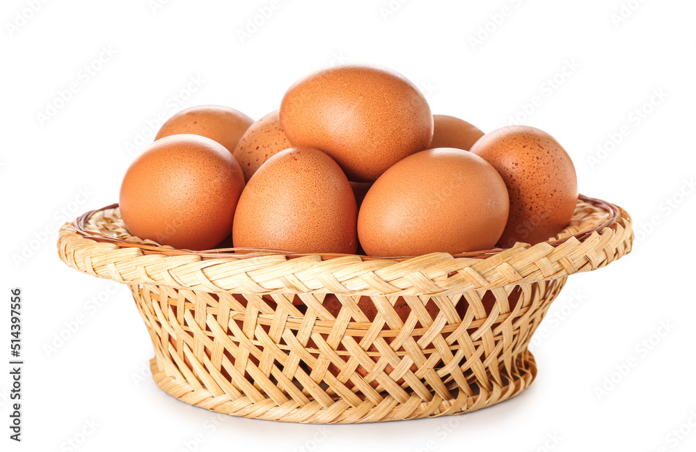 Wicker basket with brown chicken eggs on white background