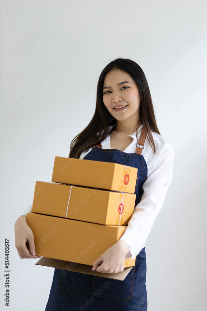 Portrait of a woman, a small start-up business owner working in a home office with parcel boxes for 